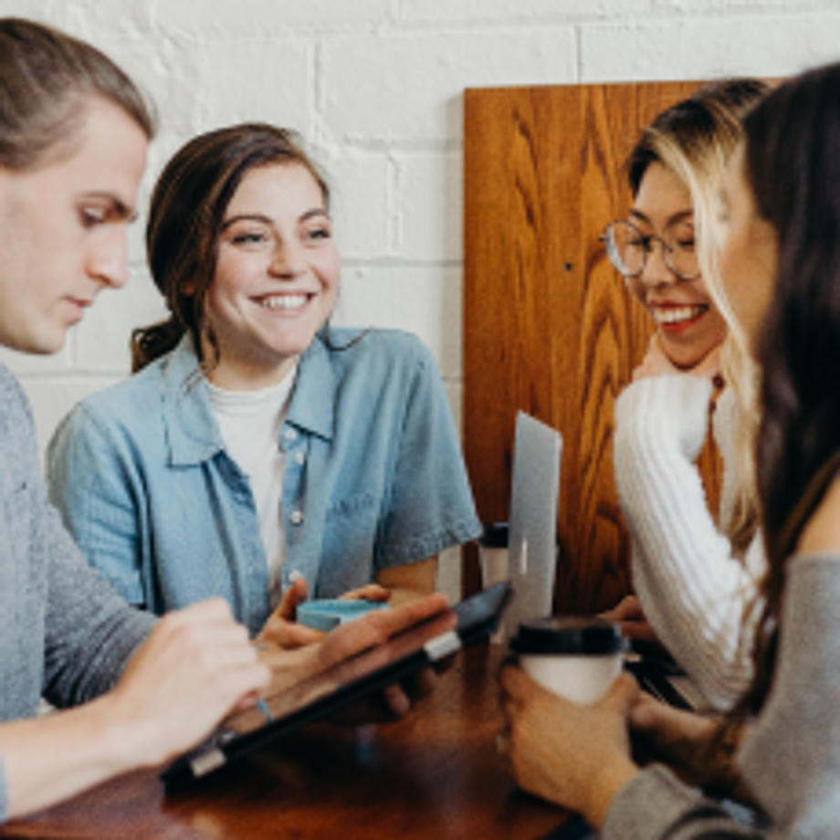 Young people chatting at a wooden table