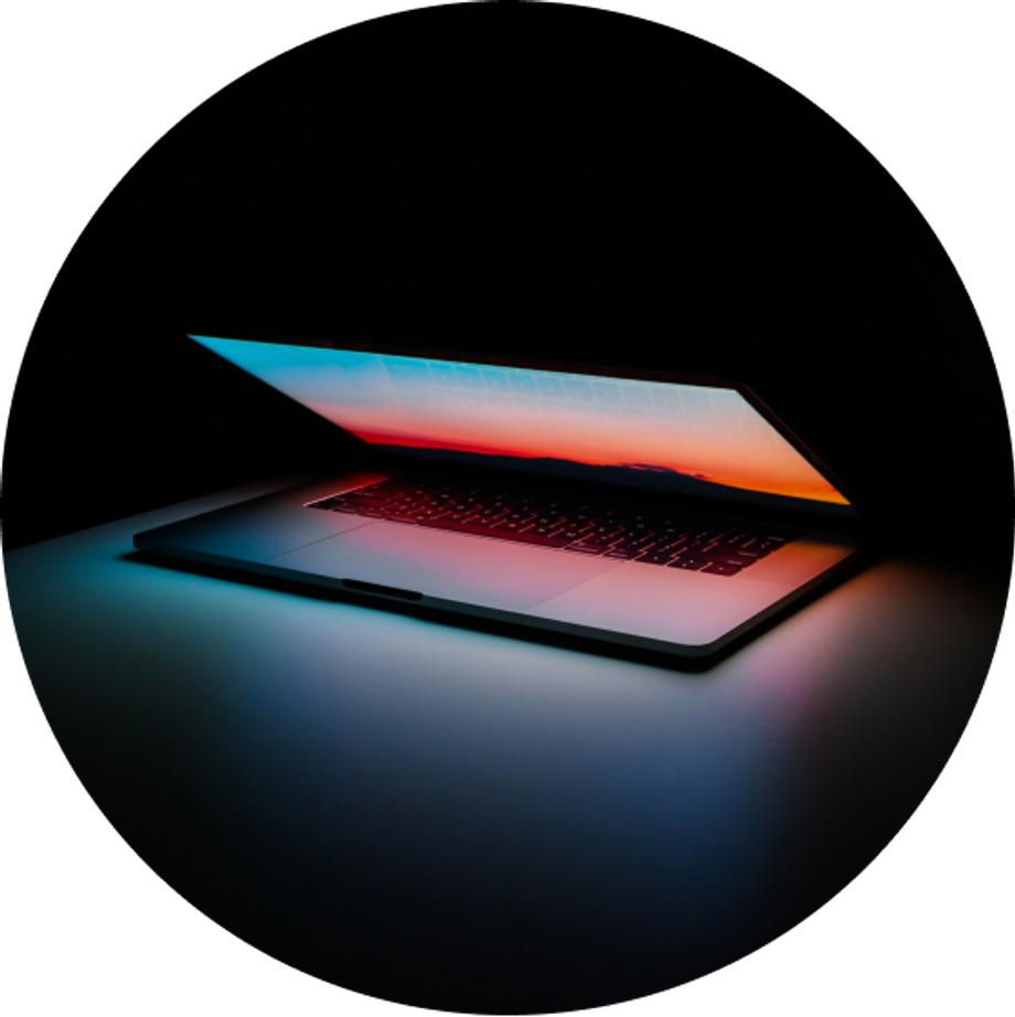 Half opened laptop computer with orange lights and a black background