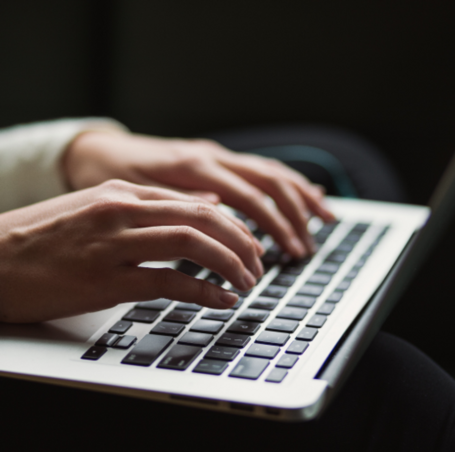 Hands typing on a computer keyboard