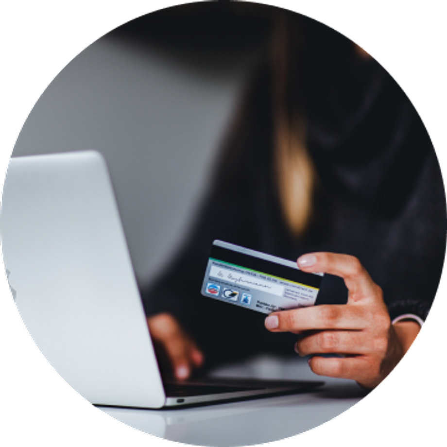 Hand of a woman handing a credit card while types on the computer