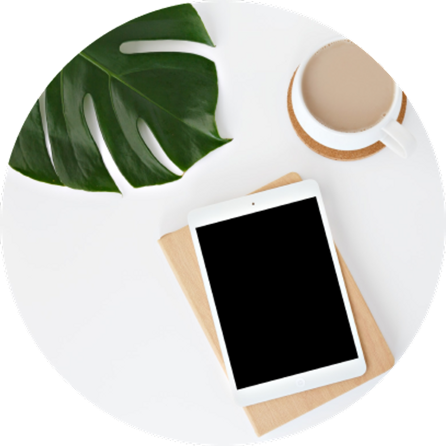 White table with a tablet, a mug and a plant