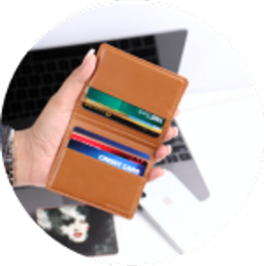 Hand holding a brown wallet with credit cards