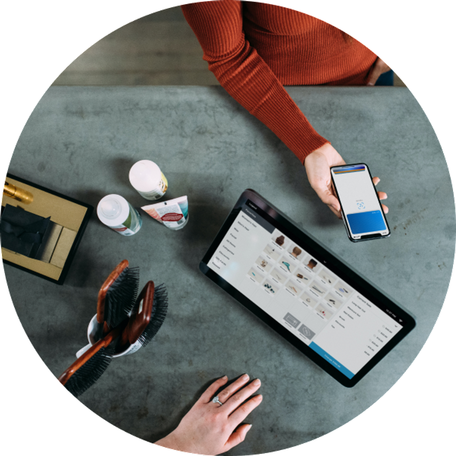 Top view of two people using cellphone and a tablet on a table