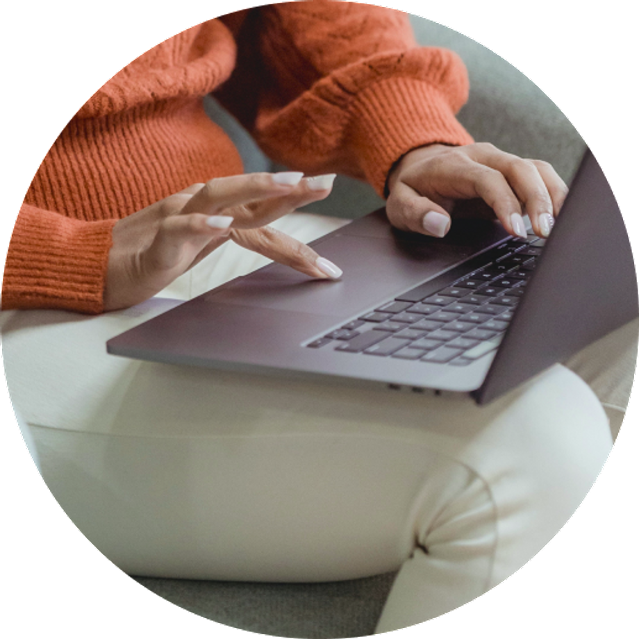 Hands of a seated woman typing on her laptop