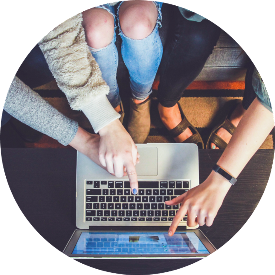 Top view of three people pointing to a laptop screen