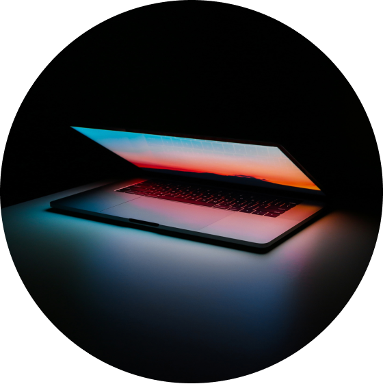 Half opened laptop computer with orange lights and a black background
